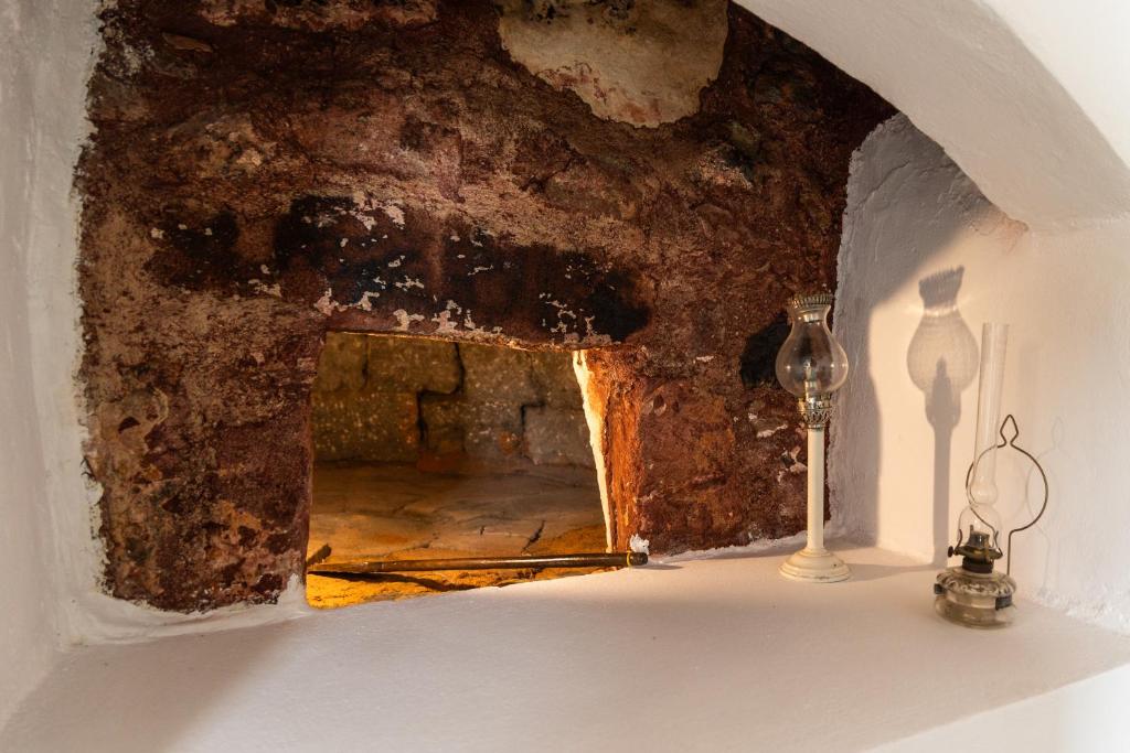 a room with a brick wall with a candle and a lamp at Lapis Domus Milos in Plaka Milou