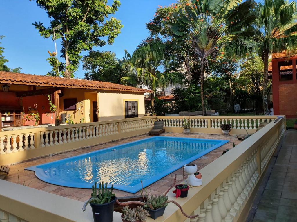 ein Schwimmbad mit einem Zaun um ein Haus in der Unterkunft Ecocentro Brasil - Bangalô 1 in São Pedro