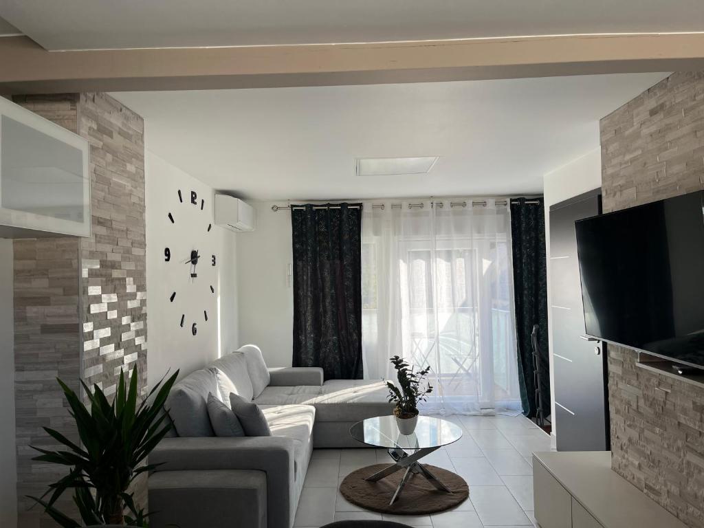 a living room with a couch and a tv at Le Coeur Champêtre in Oberhoffen-sur-Moder
