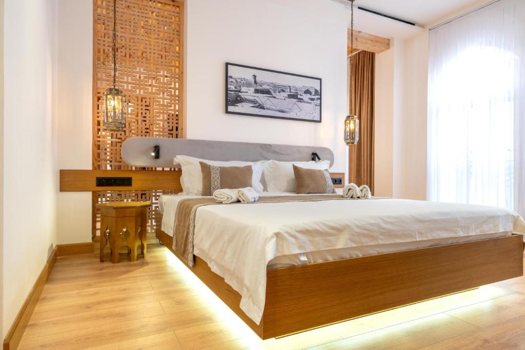 a bedroom with a large bed and a brick wall at Hotel Sarhad Bukhara in Bukhara