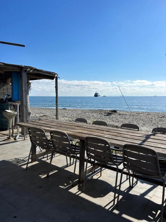 - une table et des chaises en bois sur la plage dans l'établissement Mobilhome Mare e Monte, à Lucciana