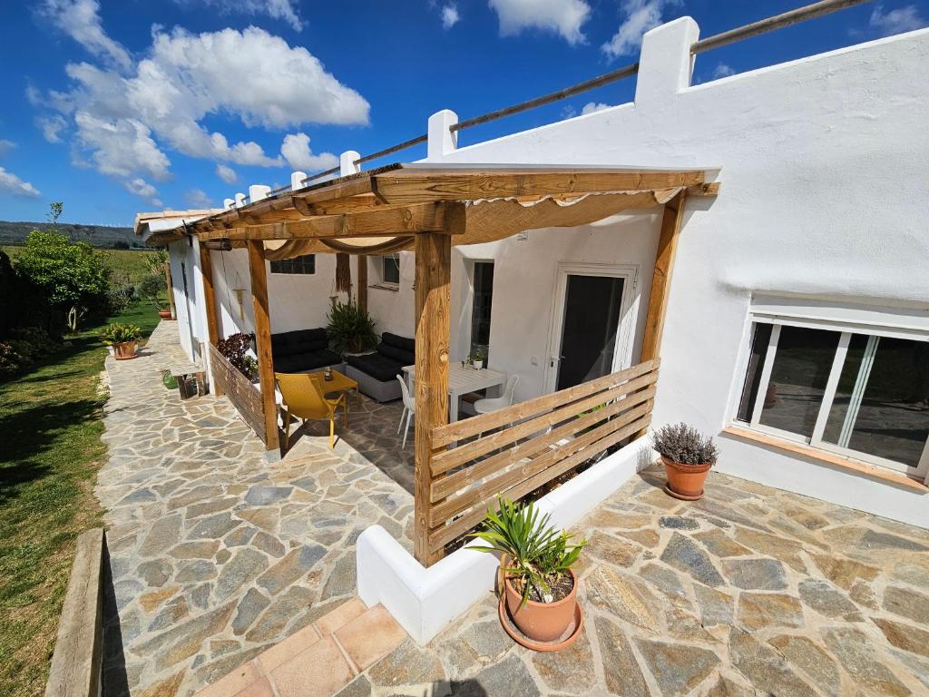 a patio with a wooden pergola on a house at Flamenca in Barbate