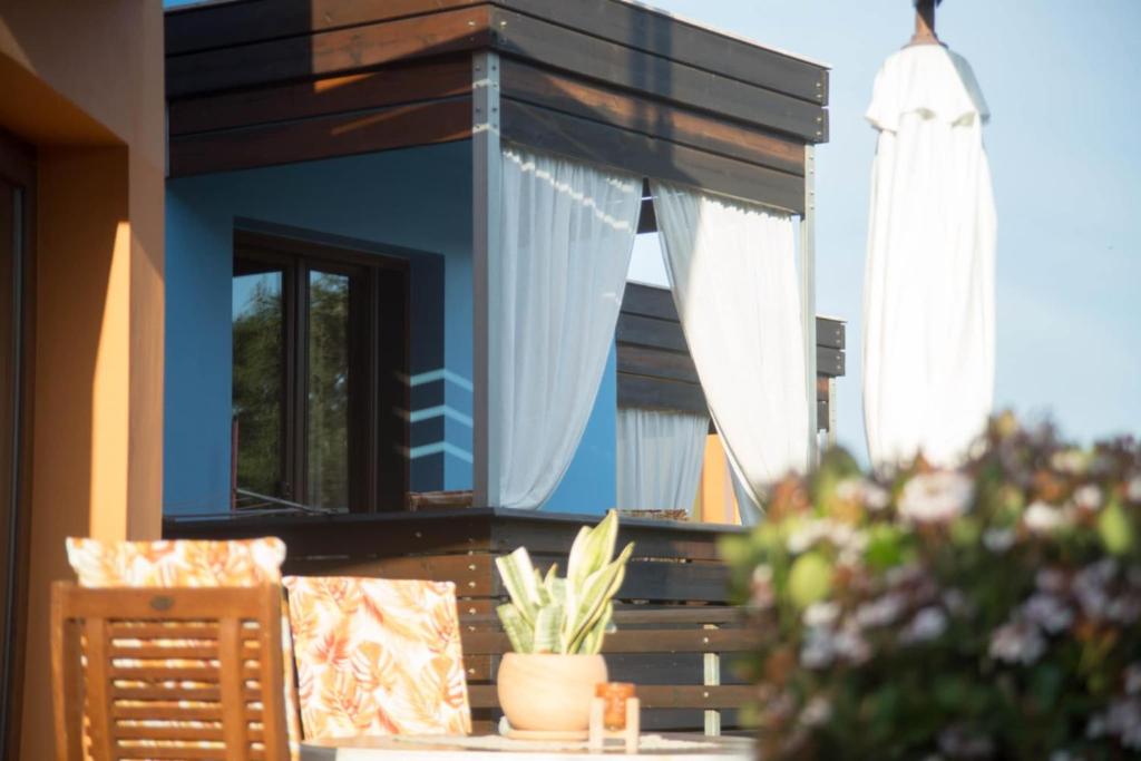 a blue house with a window and a table and chairs at AnnaDes Apartments & Studios Chios in Karfas