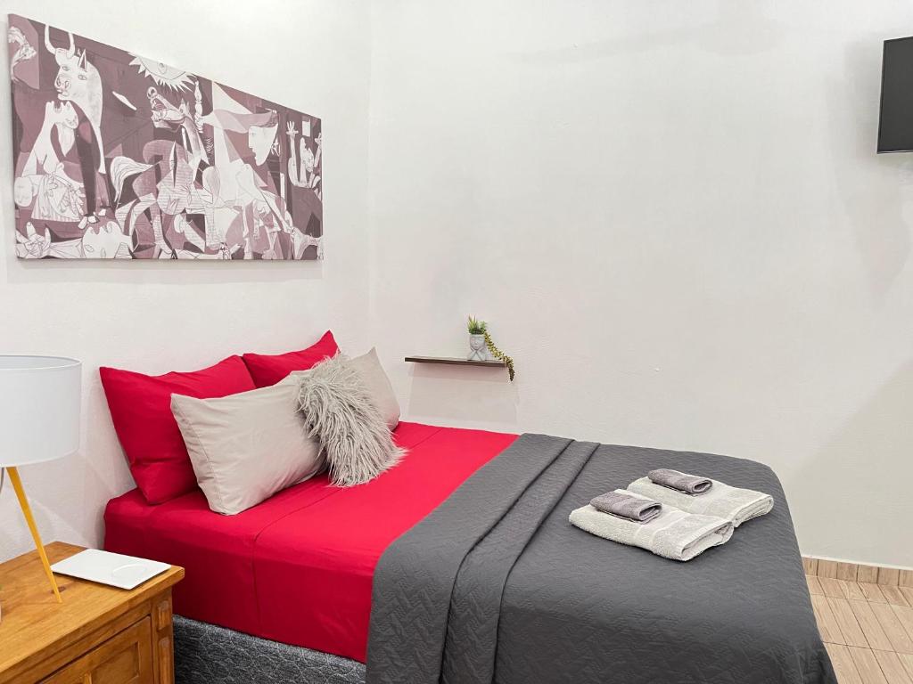 a bedroom with a red and black bed with red pillows at Coco apartamento centrico in Cozumel