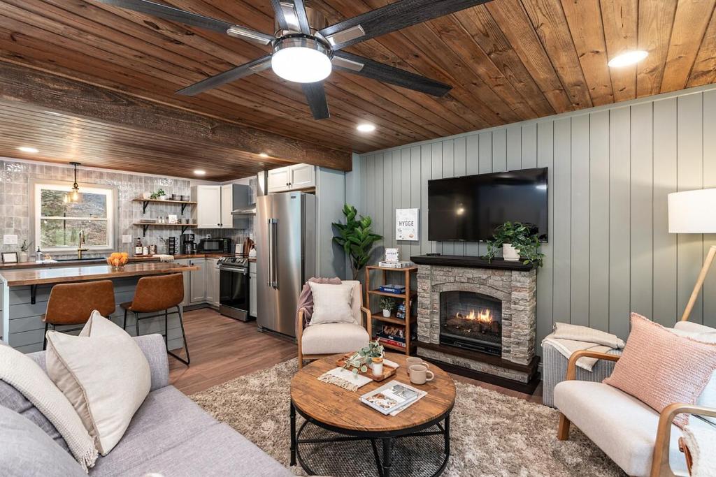 een woonkamer met een bank en een open haard bij Hot Tub - Fire Pit - River - State Park - King Bed in Wingina