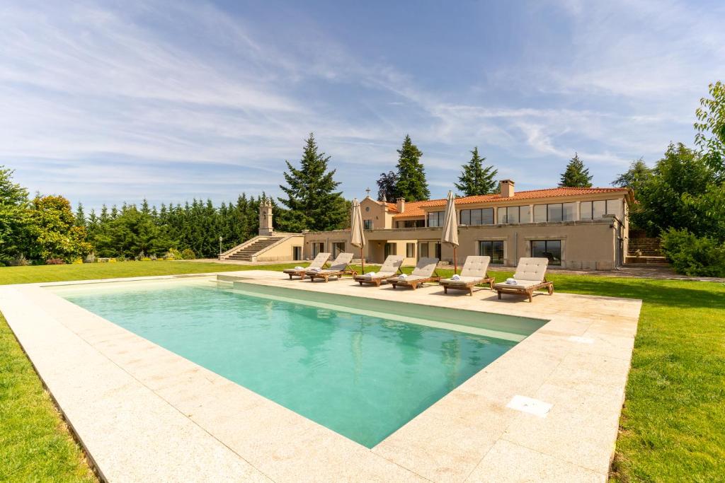 ein Swimmingpool mit Stühlen und ein Haus in der Unterkunft Casa da Raposeira Douro Valley in Armamar