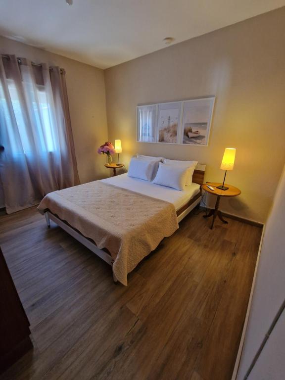 a bedroom with a bed with two lamps and two tables at Sun & Salt Keramoti in Keramoti