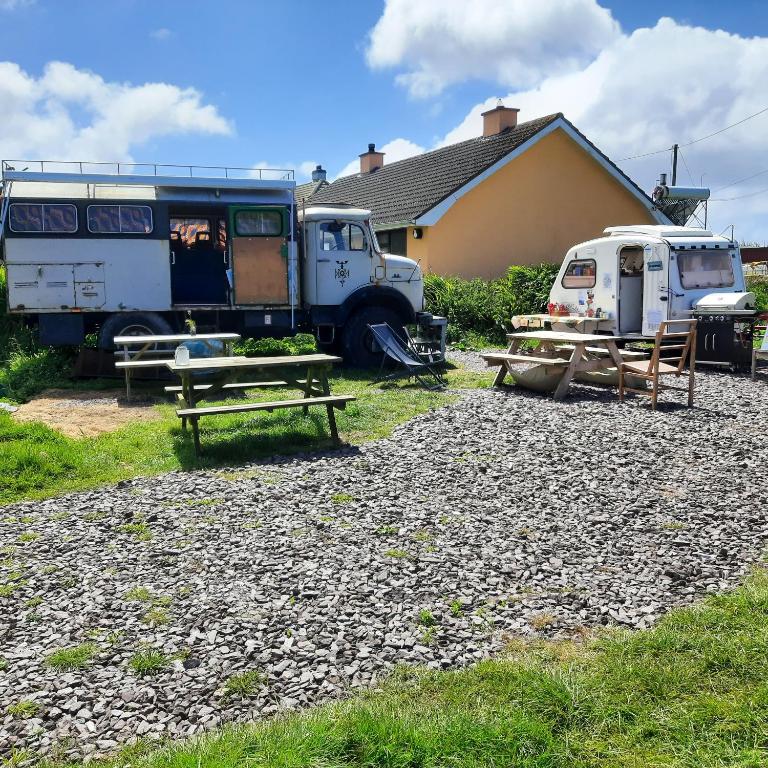 un paio di camion parcheggiati accanto a una casa di Ballincolla Base Camp a Ballinrolla