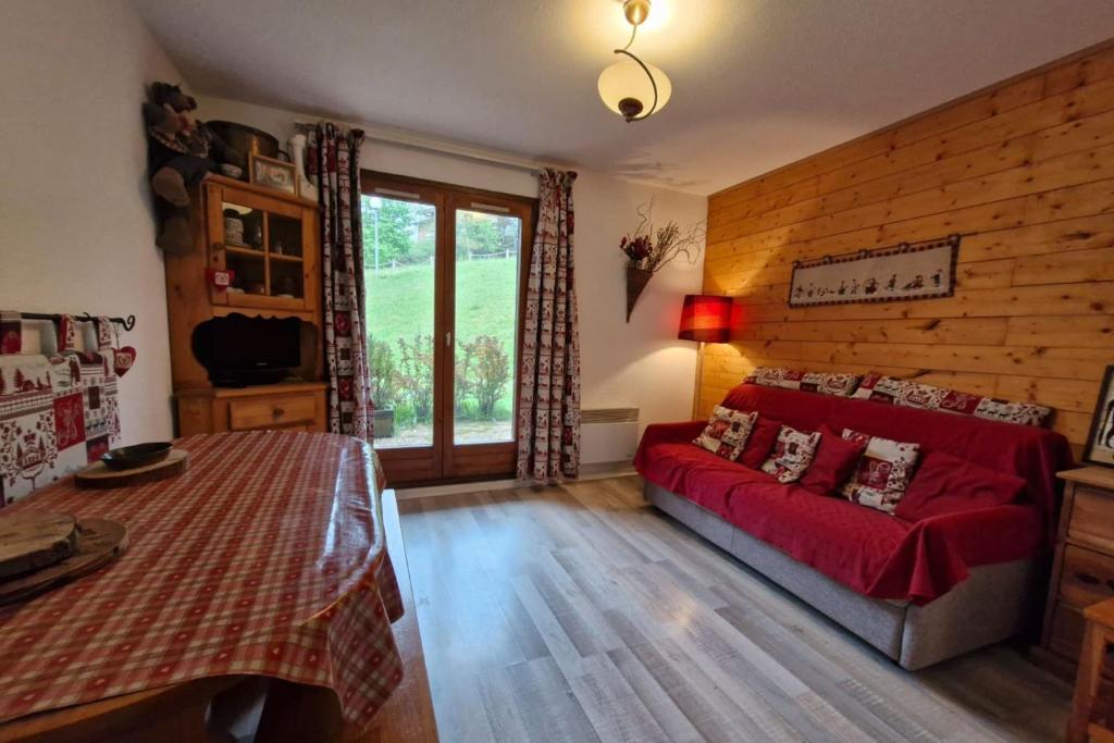 un salon avec un canapé rouge dans une chambre dans l'établissement Apartment with garden in Demi-Quartier, à Demi-Quartier