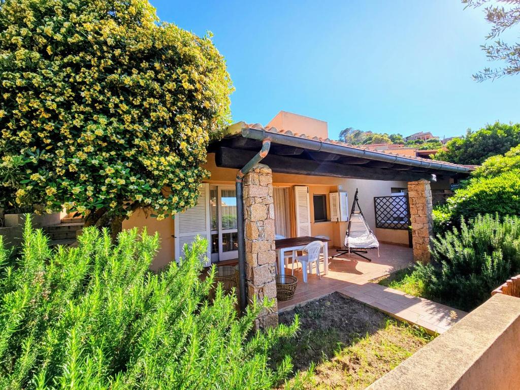 a small house with a patio and a tree at Wild Paradise in Costa Paradiso