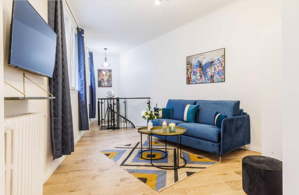 un salon avec un canapé bleu et une table dans l'établissement Beautiful duplex - 2BR 6P - Near Montmartre, à Paris