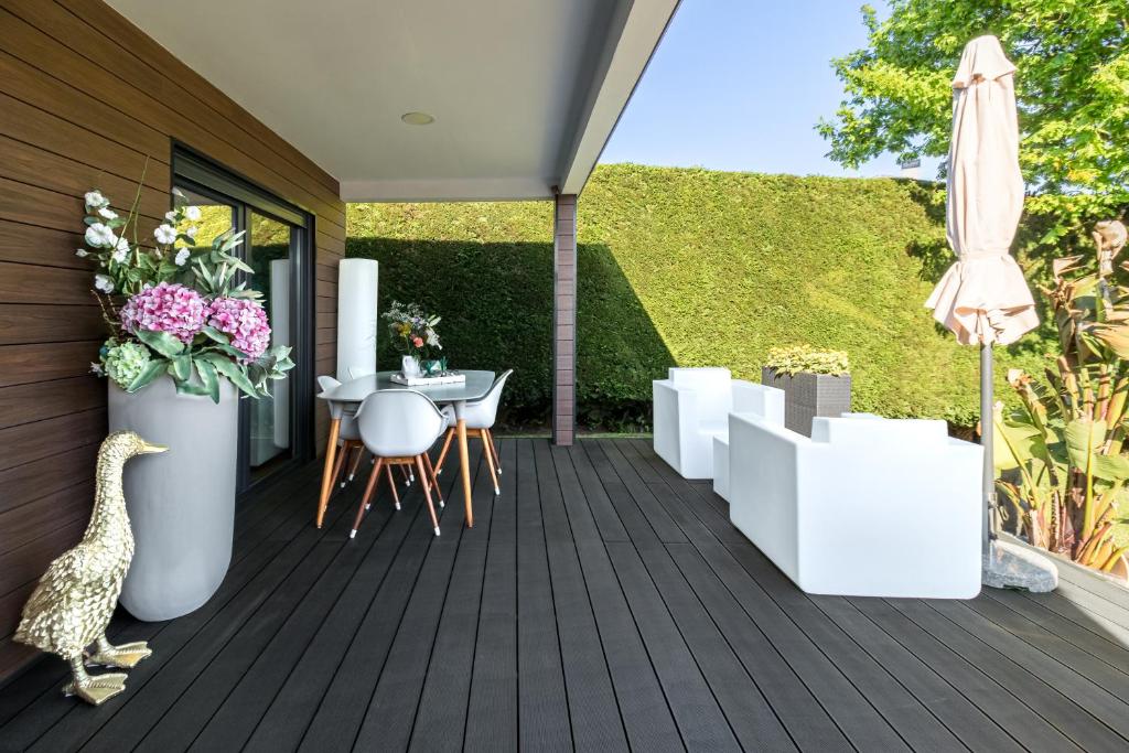 drewniany taras ze stołem i parasolem w obiekcie Norte de Santillana Villas - Apartamentos w mieście Santillana del Mar