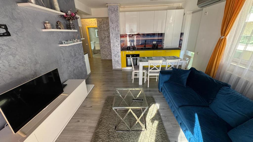 a living room with a blue couch and a table at Evo Moonlight by the sea in Mamaia