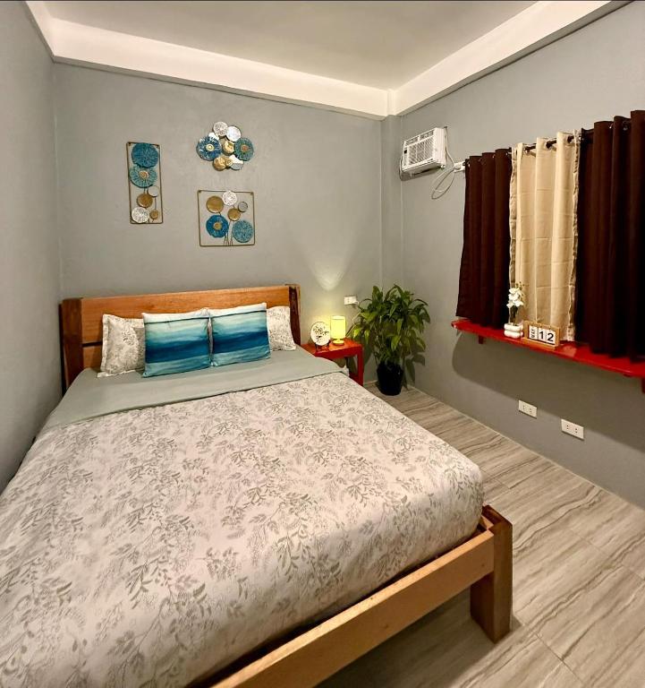 a bedroom with a large bed with blue pillows at Shanti's Inn in General Luna