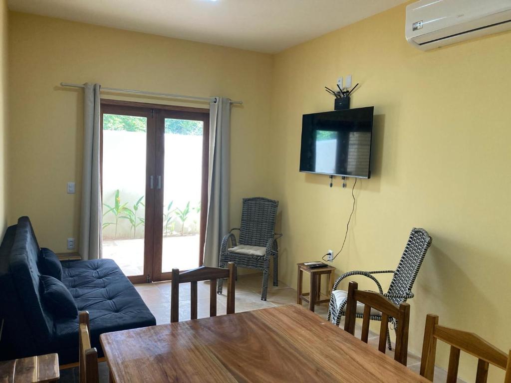 a living room with a couch and a table and chairs at Paraíso na praia in Jericoacoara