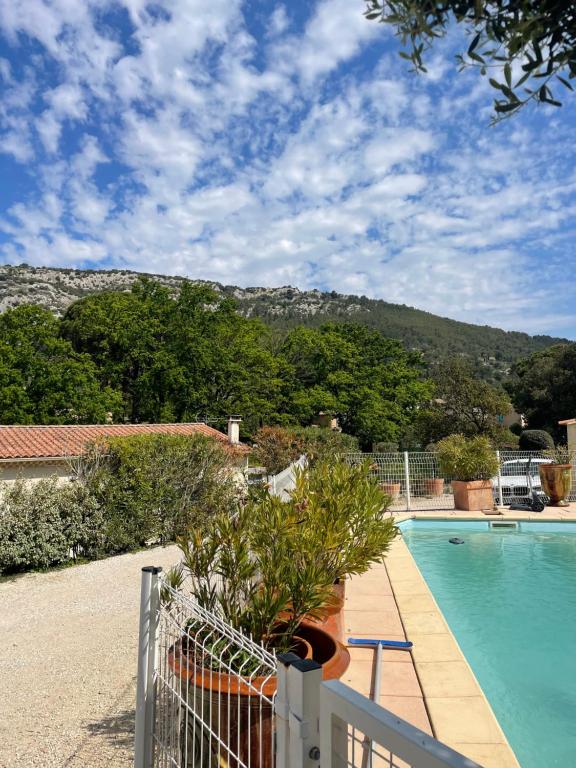 une maison avec une piscine et une montagne en arrière-plan dans l'établissement LA MAISON de BEAUMES, à Beaumes-de-Venise