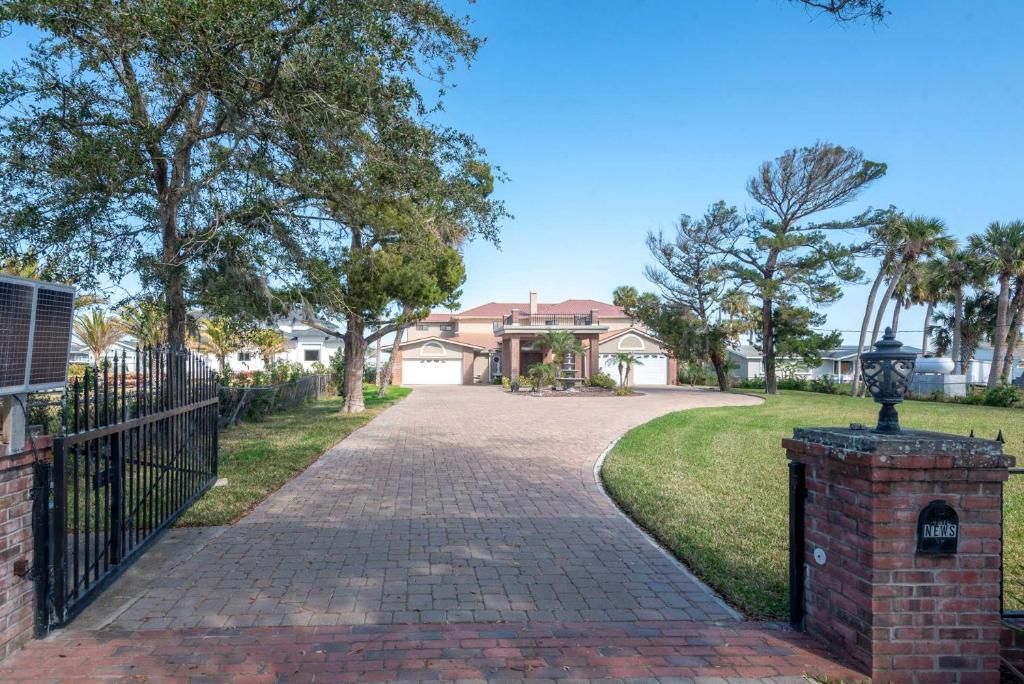 una entrada de ladrillo con una puerta delante de una casa en One of a Kind two story gated Halifax Riverfront, en South Daytona