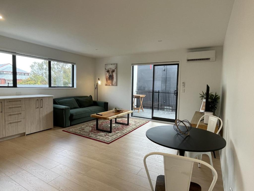 a living room with a couch and a table at Relaxing CBD Getaway in Christchurch