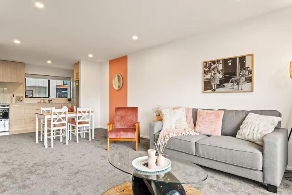 un salon avec un canapé et une table dans l'établissement Well-styled Vibrant 2 Bed Home, à Auckland