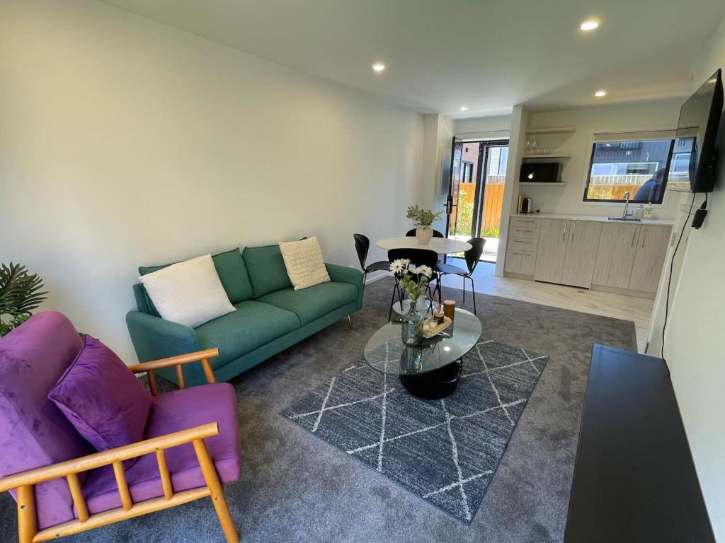 una sala de estar con un sofá y una mesa en Well-furnished Auckland Stunner, en Auckland