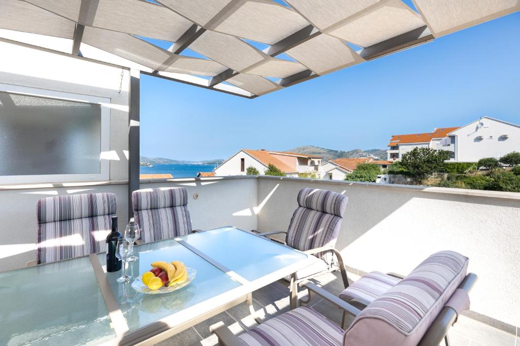 a balcony with a table and chairs and a television at Agava Lux in Trogir