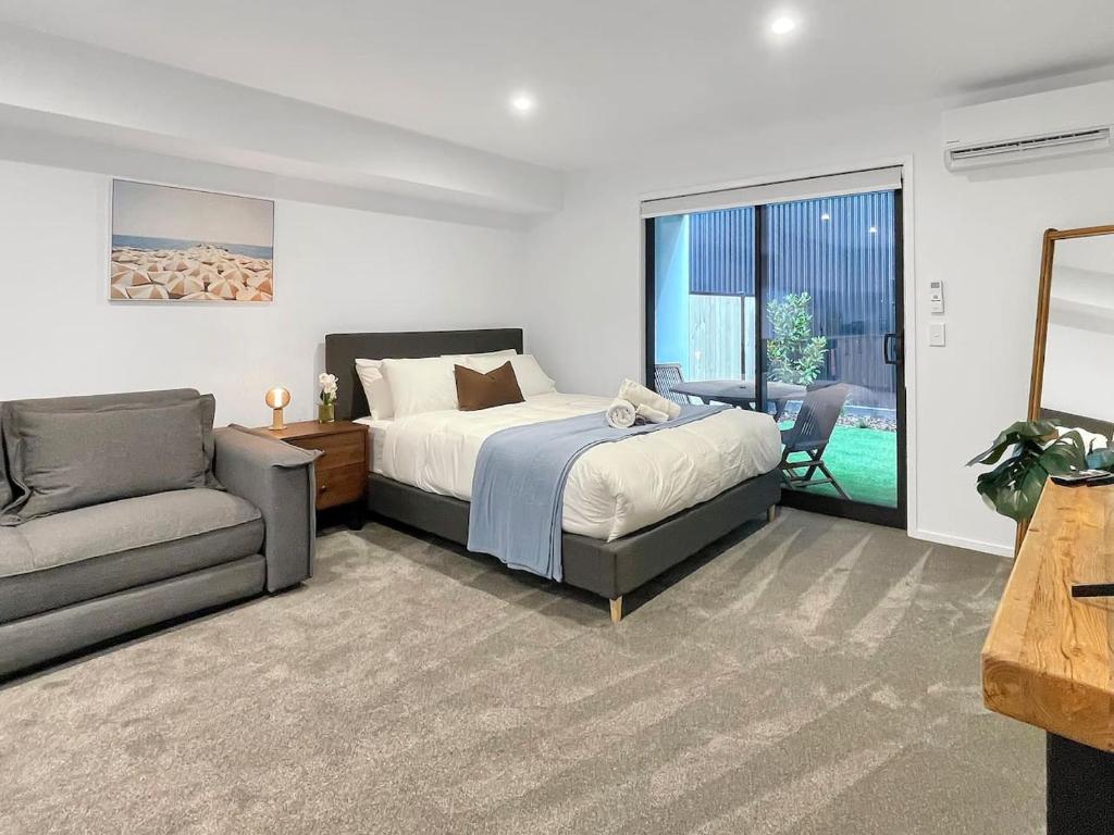 基督城CBD Gem - Studio on Allen Street的一间带床、沙发和窗户的卧室