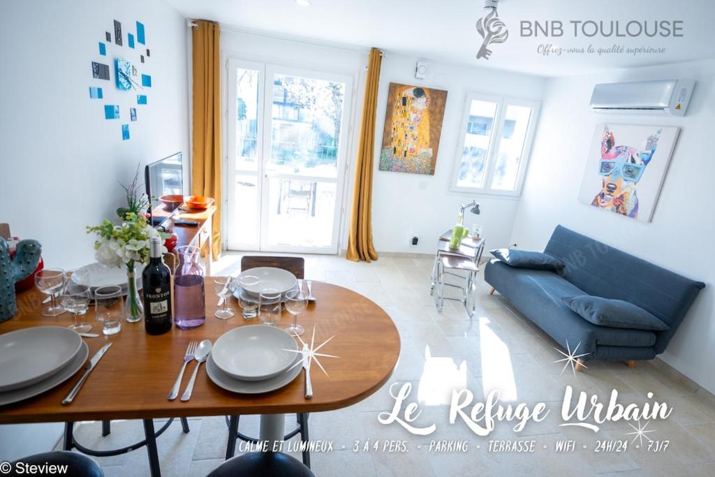 un salon avec une table et un canapé bleu dans l'établissement BNB TOULOUSE - Refuge urbain - Clim - Terrasse - Parking - WiFi - Proche transports, à Toulouse
