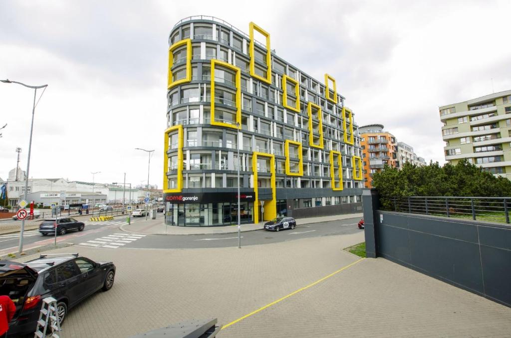 ein großes gelbes Gebäude mit davor geparkt in der Unterkunft Harmony106 in Prag