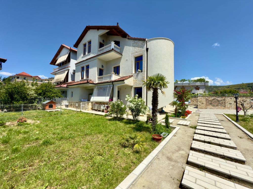 une grande maison blanche avec une cour en face de celle-ci dans l'établissement Villa Ida Apartments, à Vlorë