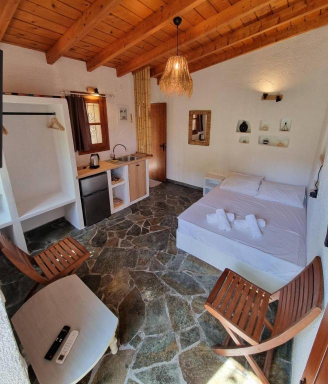 a bedroom with a bed and a table and chairs at Fay's Guesthouse Aegina in Egina