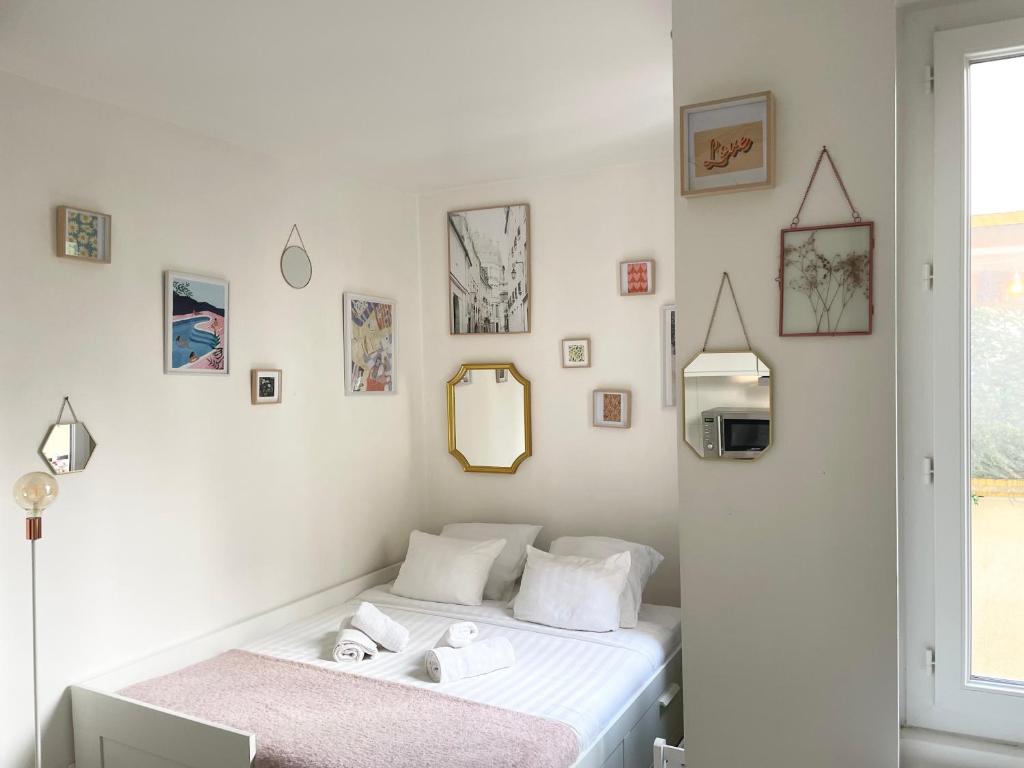 - une chambre blanche avec un lit et des serviettes dans l'établissement Cocon Montmartre - Netflix, Fibre & Conciergerie, à Paris