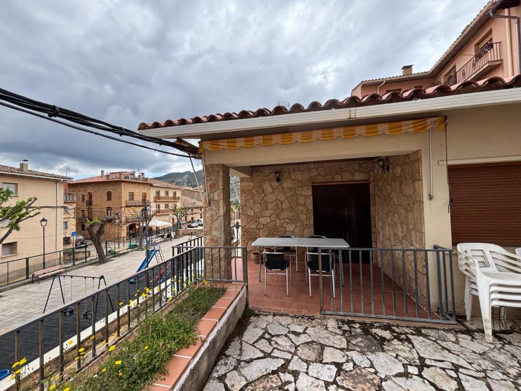 Un balcón de una casa con una mesa y sillas. en Casa Ángeles, en Beceite