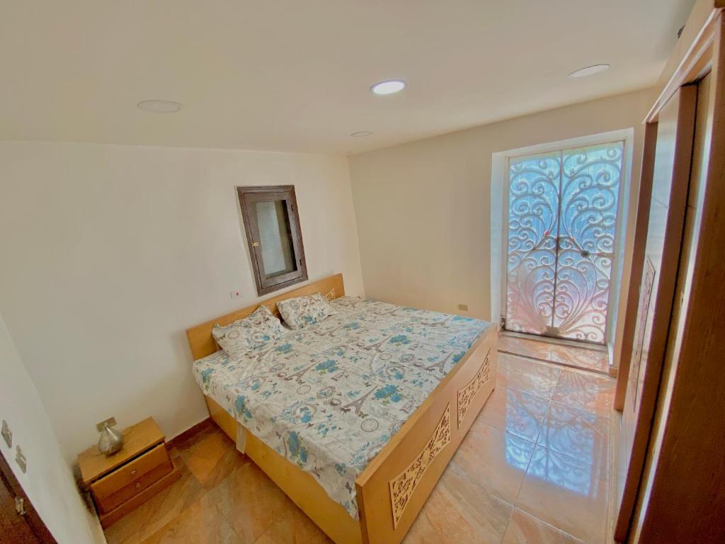 a bedroom with a bed and a window at Yellow House on the Nile in Luxor
