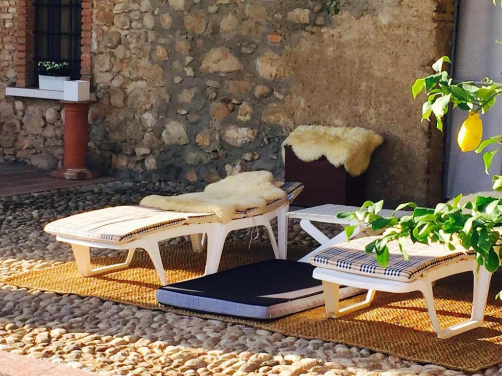 ロナートにあるAntico Cascinale Lombardoの中庭に白い椅子2脚とテーブル
