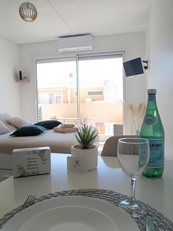 une table avec un verre à vin et une chambre avec un lit dans l'établissement Studio tout confort avec place de parking et wifi, à Balaruc-les-Bains