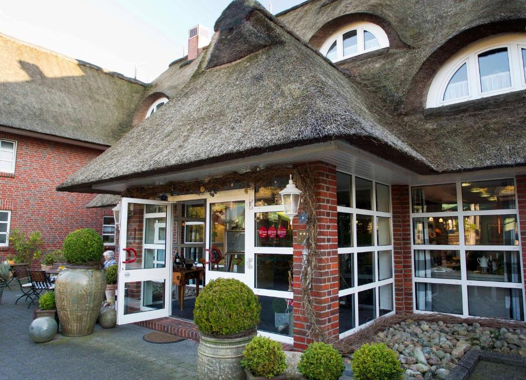 a building with a thatched roof with a store at Hotel Graf Bentinck in Dangast