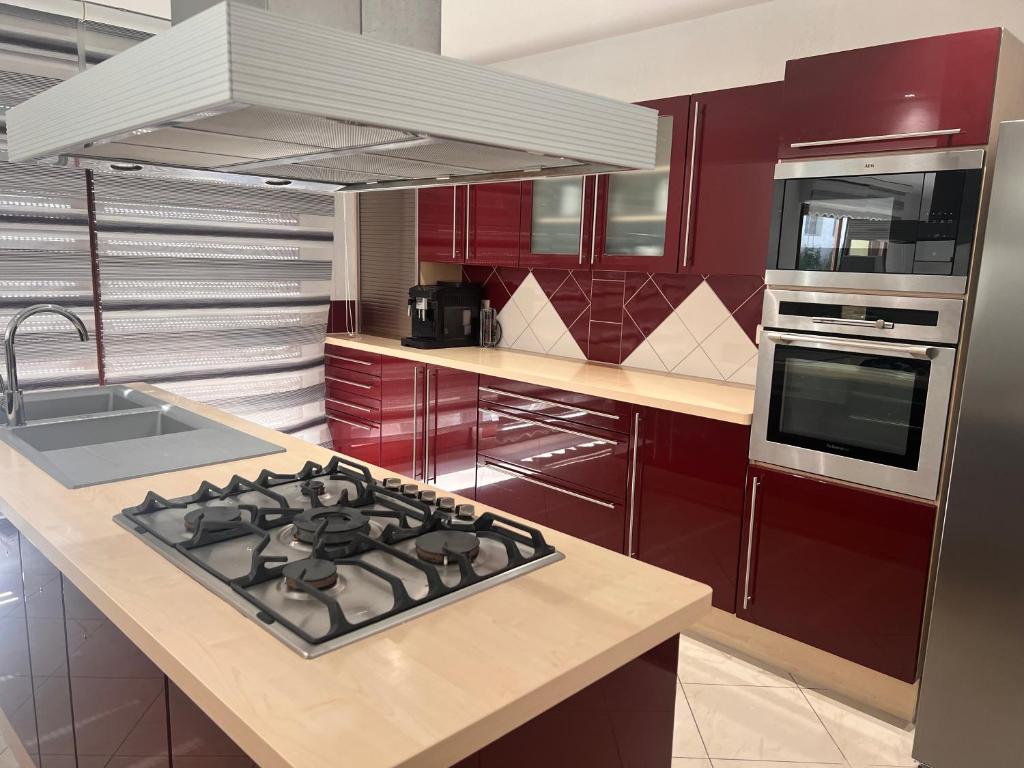 a kitchen with red cabinets and a stove top oven at Venez au cœur de la route des vins et des marchés de Noël in Beblenheim