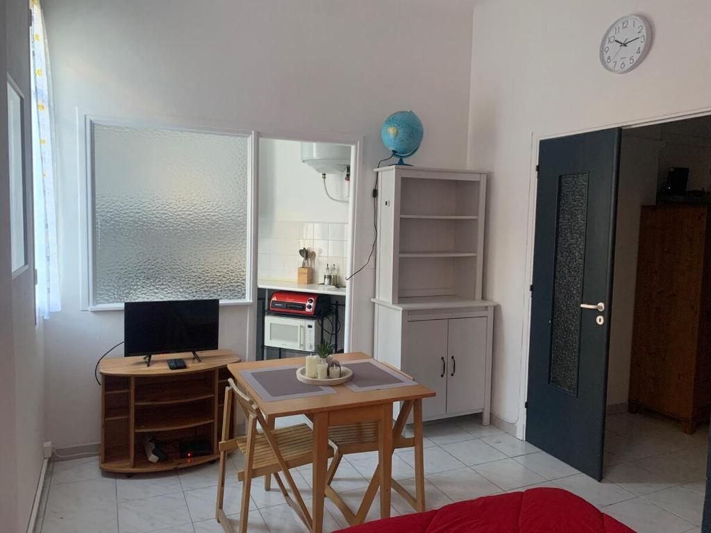 une petite cuisine avec une table et un bureau avec un ordinateur dans l'établissement Nice studio close to the sea, à Nice