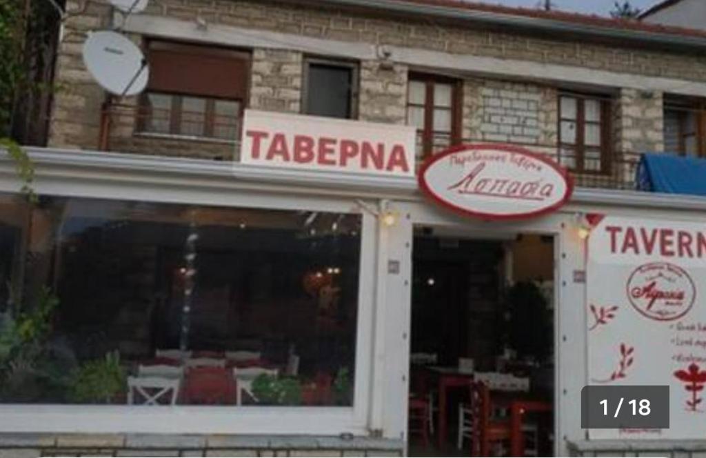 een restaurant met tafels in het raam van een gebouw bij Sergios Rooms votonosi metsovo!!! in Votonósion