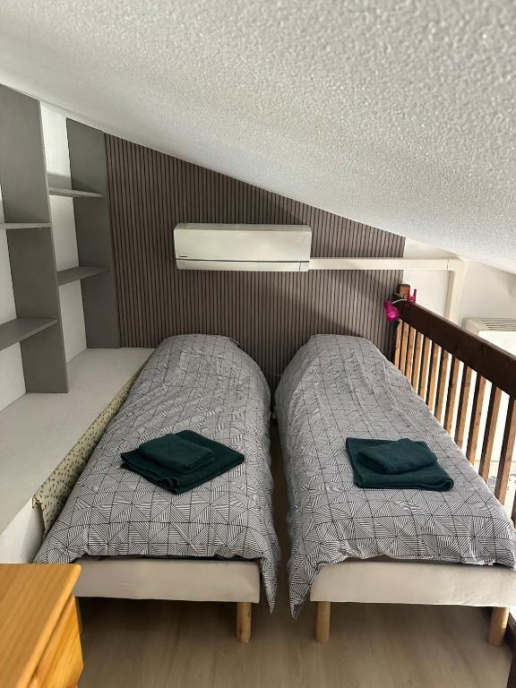 - une chambre avec 2 lits pourvus d'oreillers verts dans l'établissement Charmant appartement proche plages avec vue montagne, à Argelès-sur-Mer