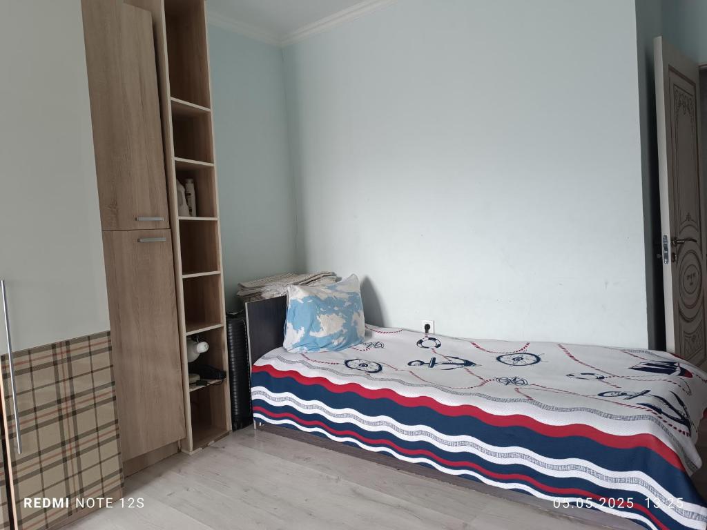 ein Schlafzimmer mit einem Bett und einem Bücherregal in der Unterkunft Жунисова 14 in Zhezdi