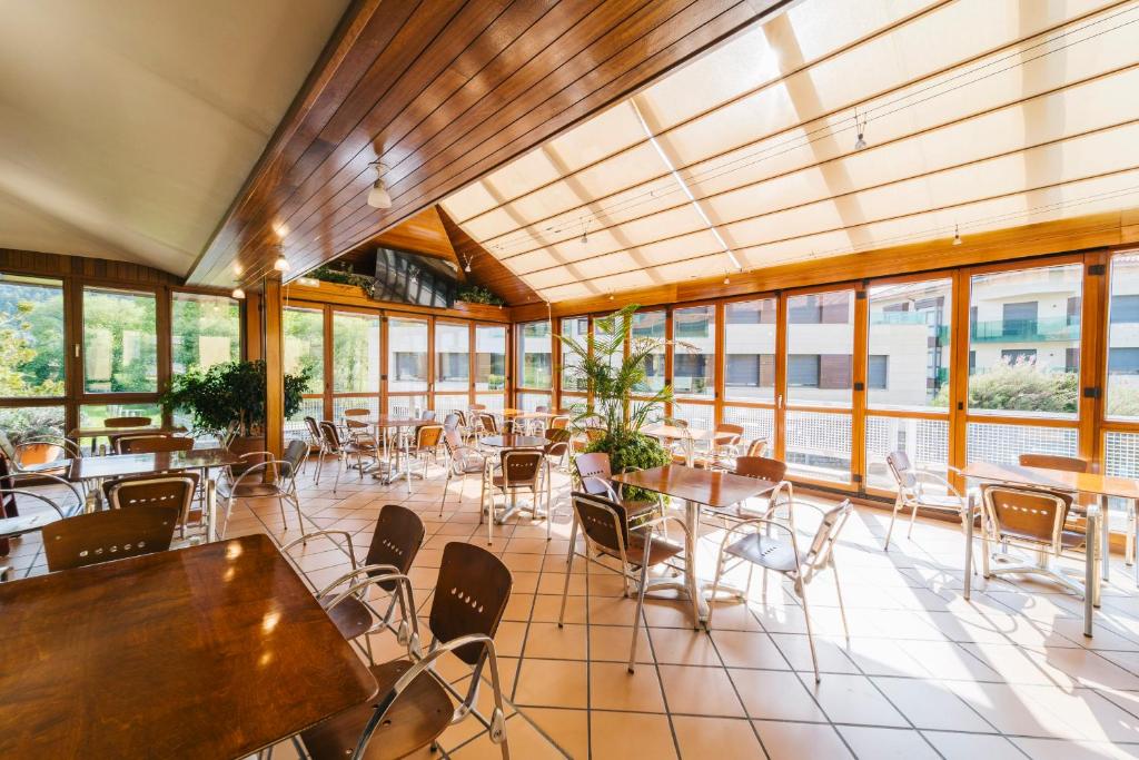 a restaurant with tables and chairs and windows at Miracielos in Barro de Llanes