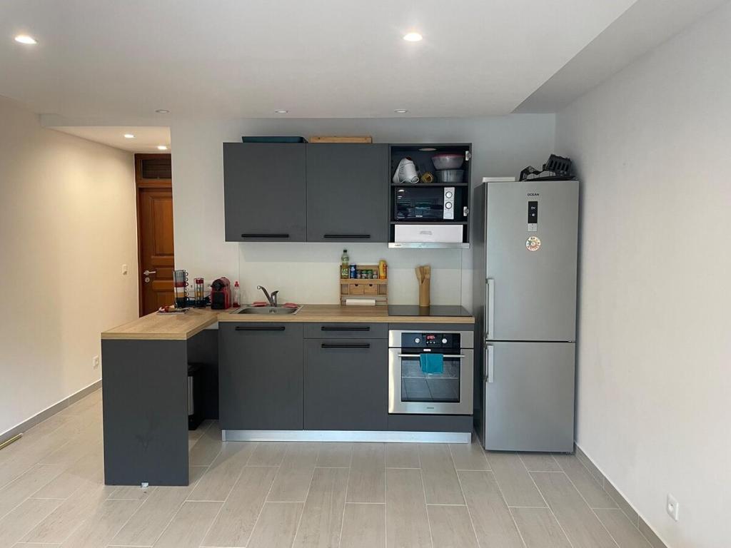 cocina con nevera de acero inoxidable y encimeras en Studio Marigot Fort Louis, en Marigot