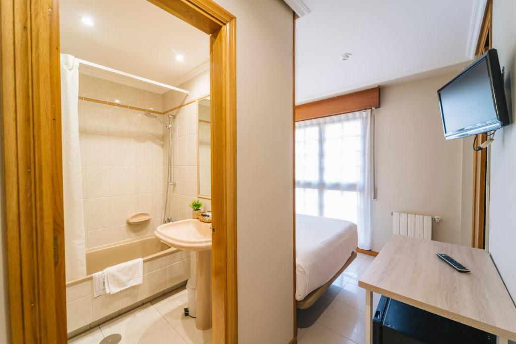 a bathroom with a bed and a sink and a toilet at Miracielos in Barro de Llanes