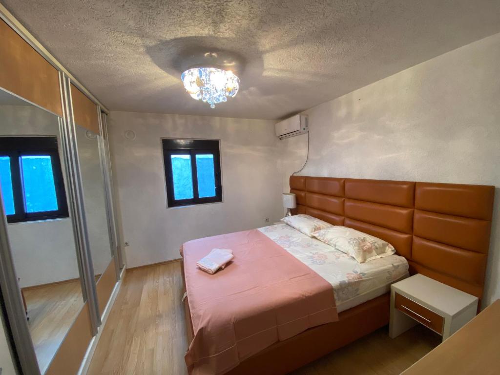 a small bedroom with a bed and a chandelier at Centerside Apartment in Ulcinj