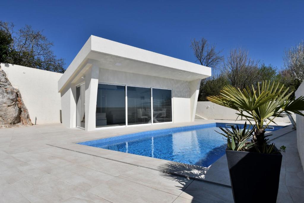 a white house with a swimming pool in front of it at House Luxury in Matulji