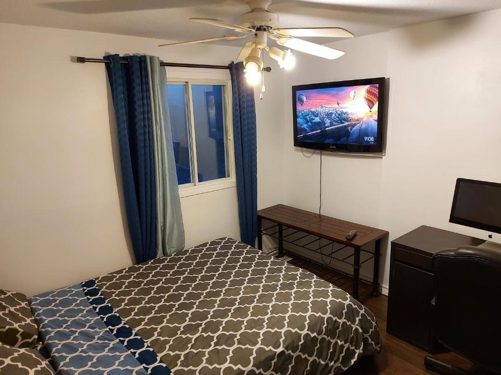 a bedroom with a bed and a flat screen tv at Bedroom in cozy townhome in Gatineau