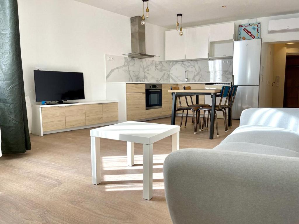un salon avec une table et une cuisine dans l'établissement Suite moderne à Draguignan - Élégance Urbaine, à Draguignan
