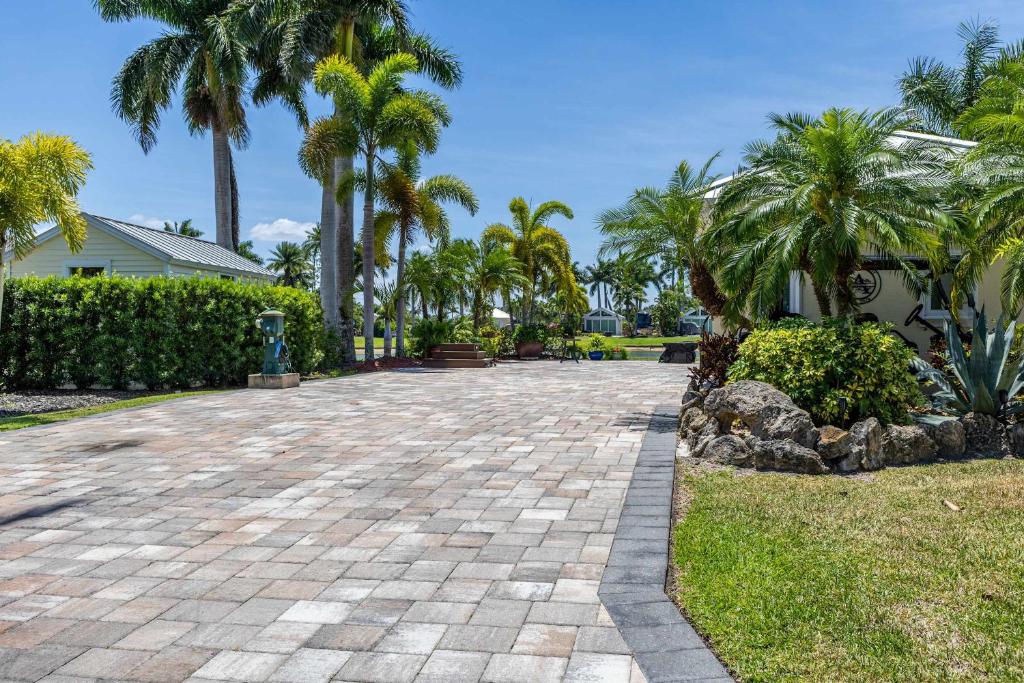 Riverbend Motorcoach Resort Lot 93 في La Belle: ممر مع أشجار النخيل والمنزل