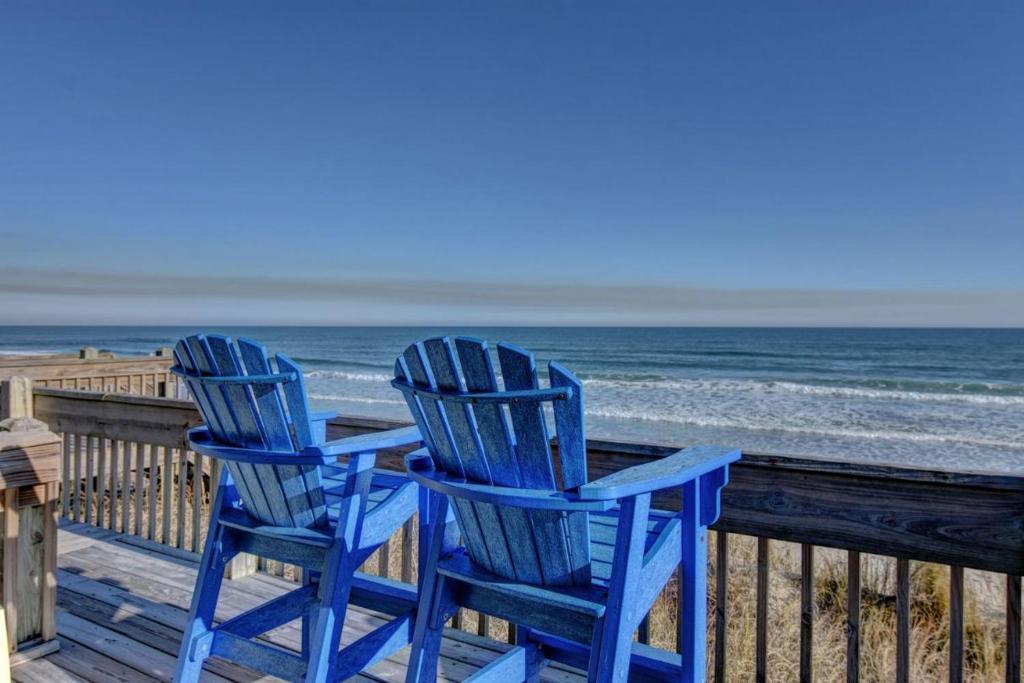 twee blauwe stoelen op een tafel op het strand bij Turtle Cove 908D in Surf City